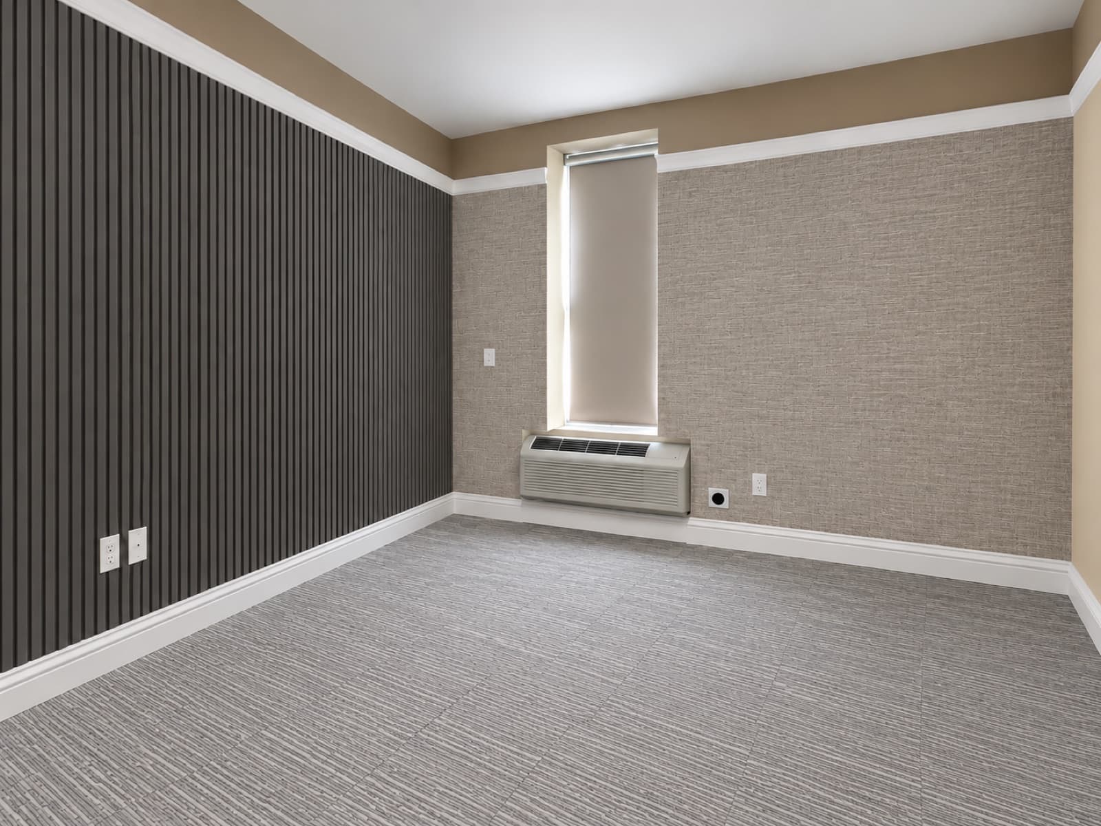 The empty room, window side with the slatted accent wall at The 46, 129 West 46th Street, Midtown NYC