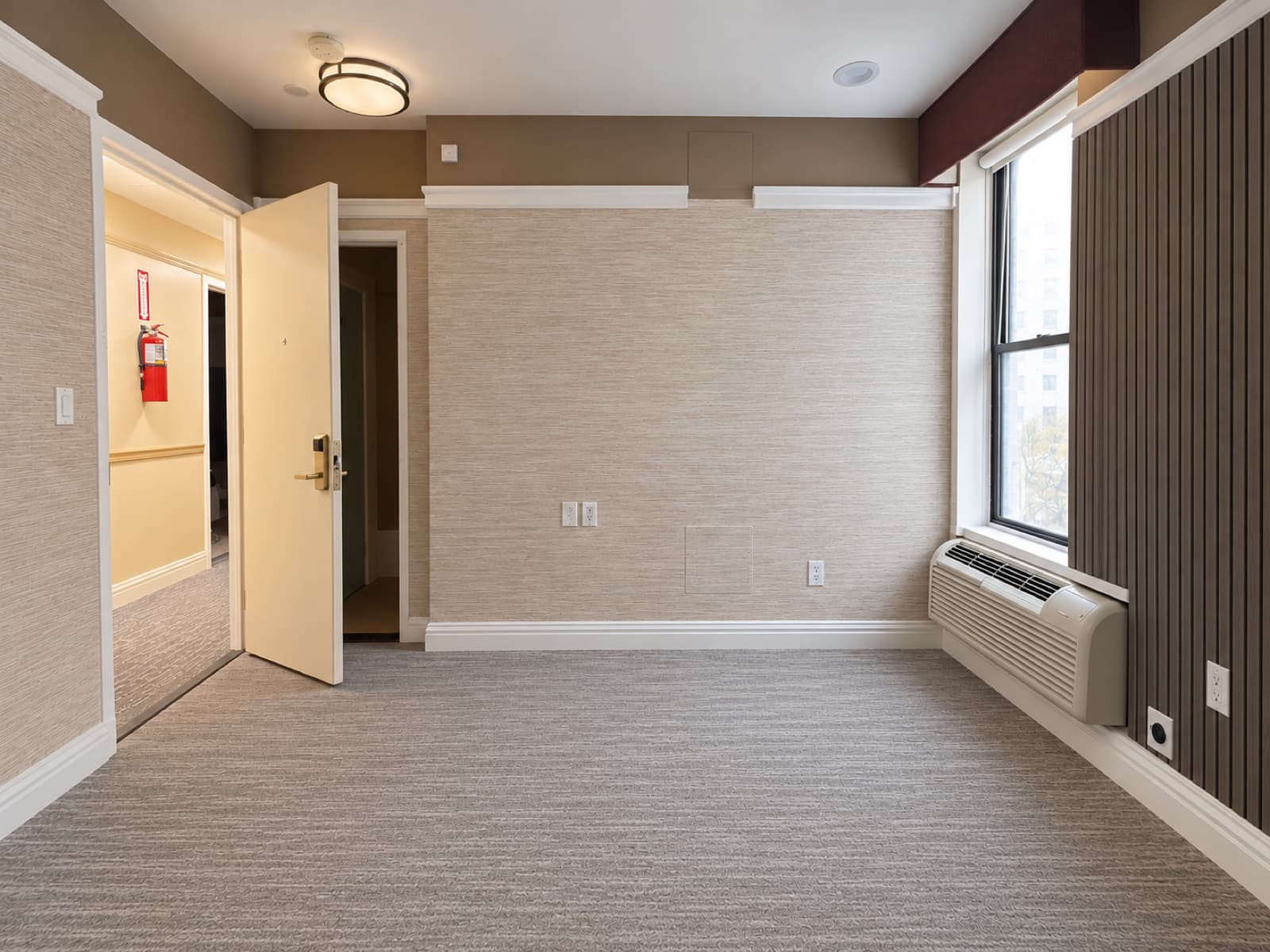 The empty room, looking toward the entry and window at The 46, 129 West 46th Street, Midtown NYC